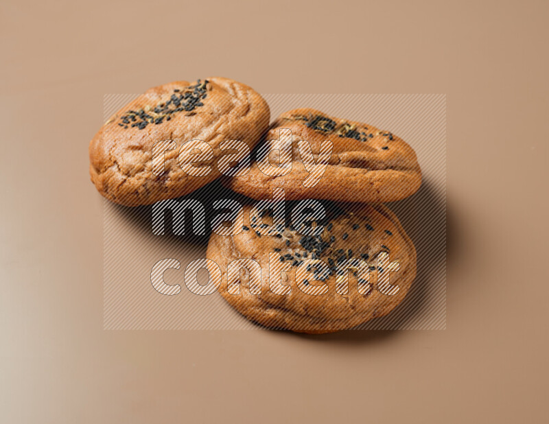 Hasawi cookies field with date and decorated by black seed and Anise grain on a brown background