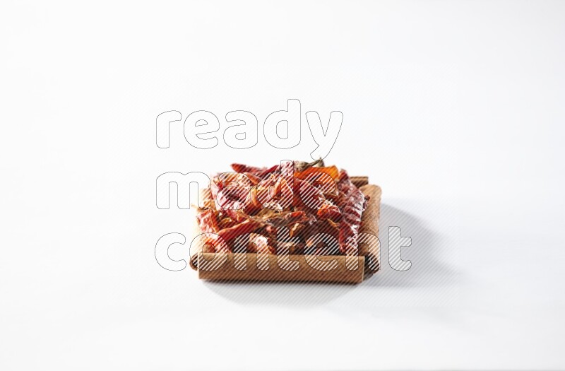 A single square of cinnamon sticks full of chilis on white flooring