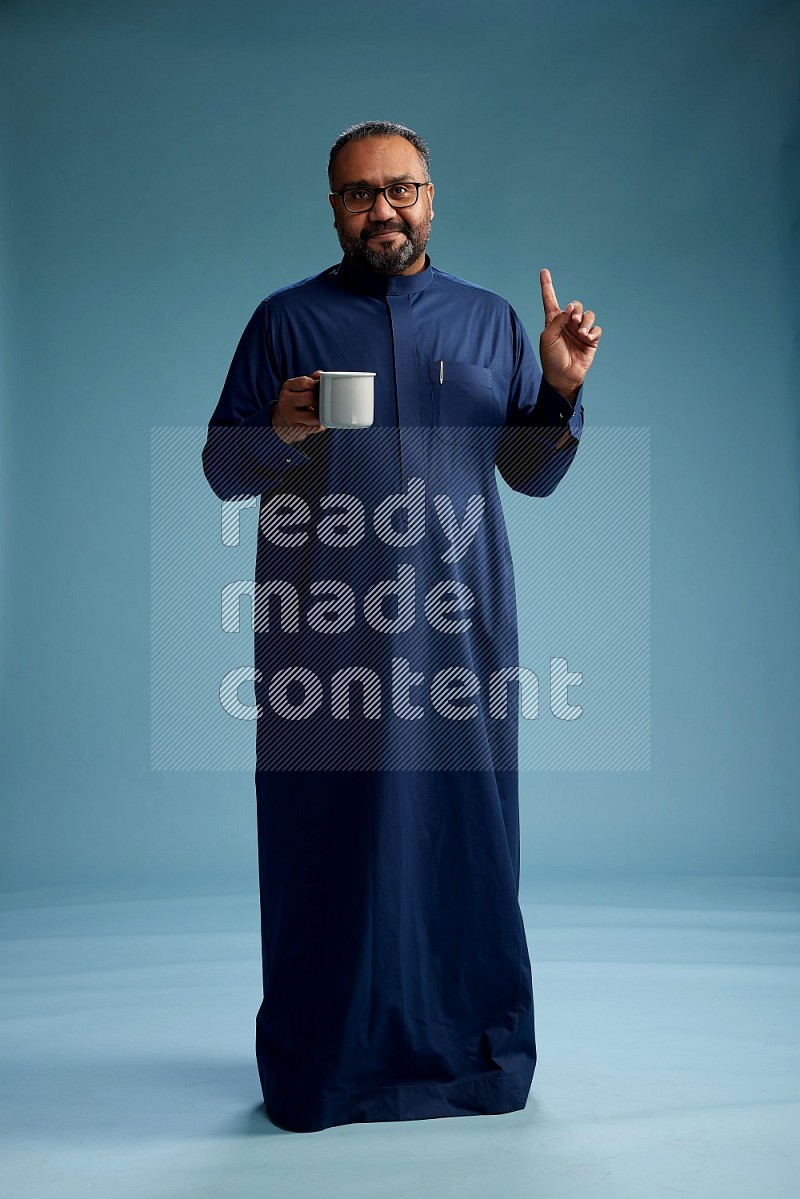 Saudi Man without shimag Standing drinking coffee on blue background