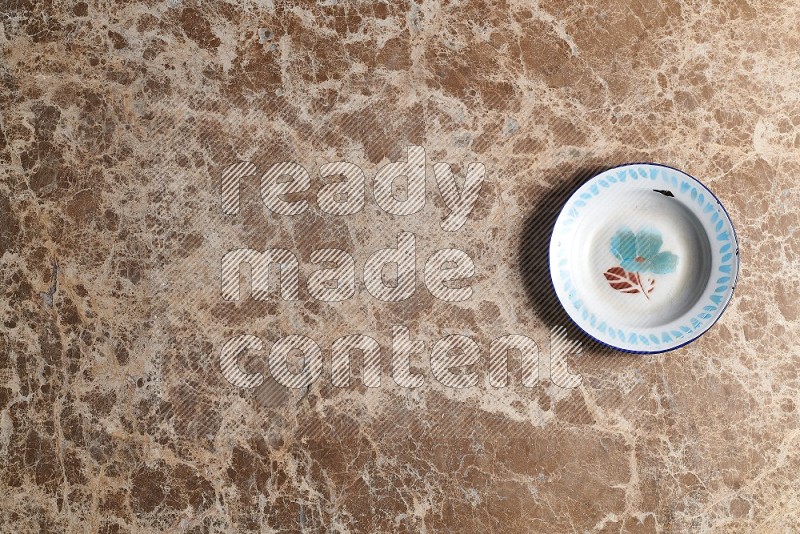 Top View Shot Of A Vintage Metal Plate On beige Marble Flooring