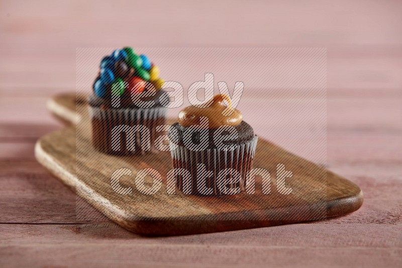 Chocolate mini cupcake topped with peanut butter on a wooden board