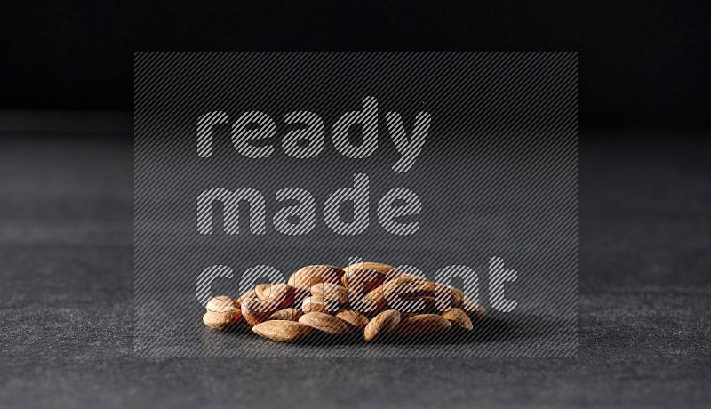A bunch of peeled almonds on a black background in different angles