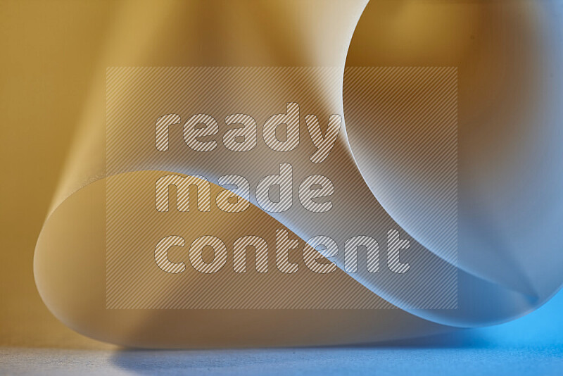 An abstract art piece displaying smooth curves in blue and gold gradients created by colored light