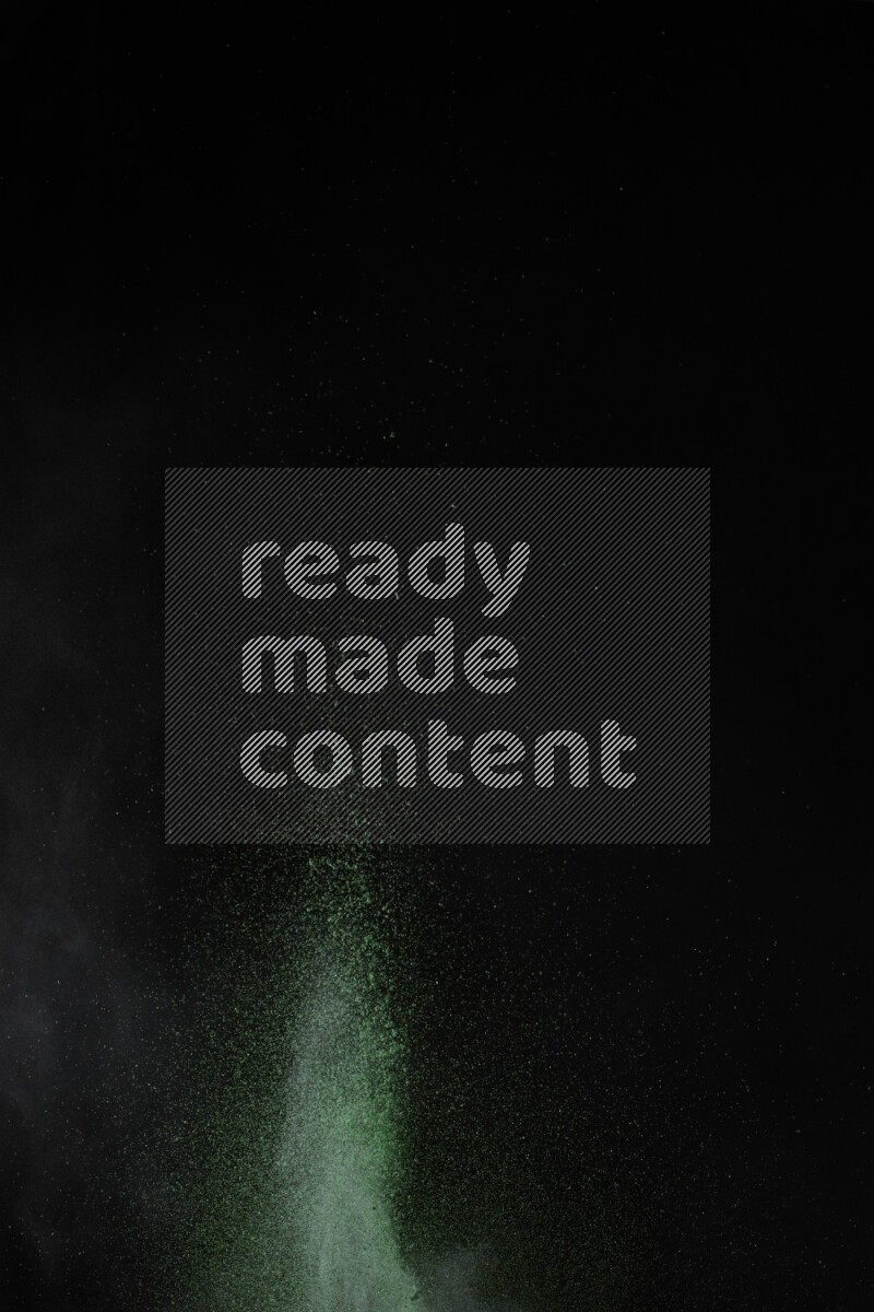 A side view of green powder explosion on black background
