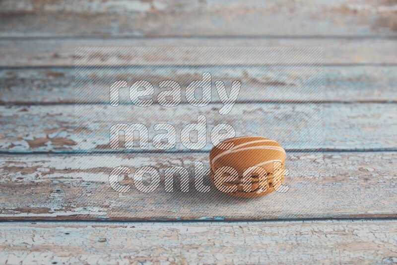 45º Shot of Brown Irish Cream macaron on light blue wooden background