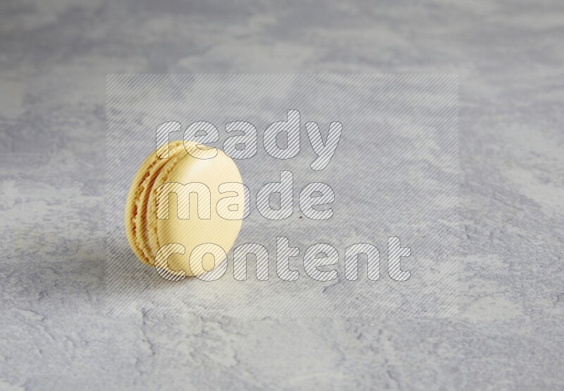 45º Shot of Yellow Vanilla macaron on white  marble background