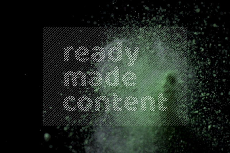 Green powder explosion on black background