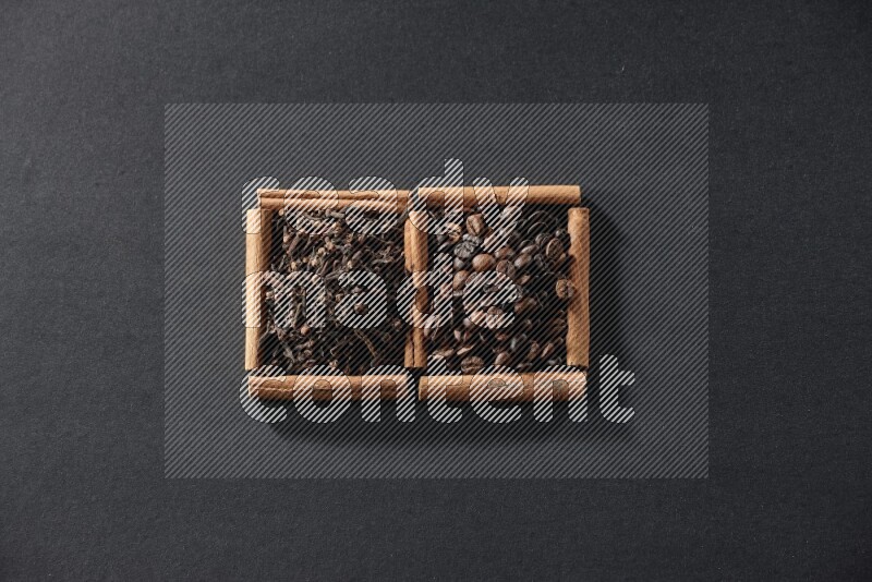 2 squares of cinnamon sticks full of coffee beans and cloves on black flooring