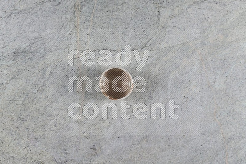 Top View Shot Of A Multicolored Pottery Bowl On Grey Marble Flooring