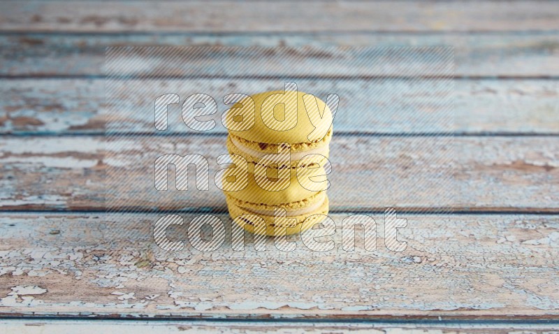 45º Shot of two Yellow Lime macarons on light blue wooden background