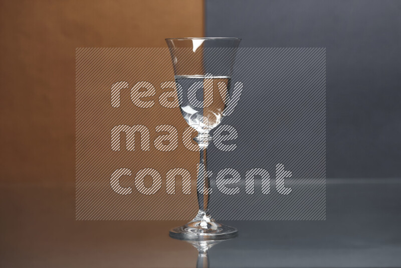 The image features a clear glassware filled with water, set against brown and dark blue background