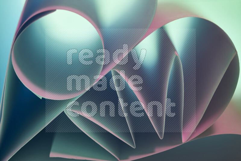 عرض فني لطيات الورق تخلق مزيج من الأشكال الهندسية، مضاءة بإضاءة ناعمة بدرجات اللون الأخضر والوردي