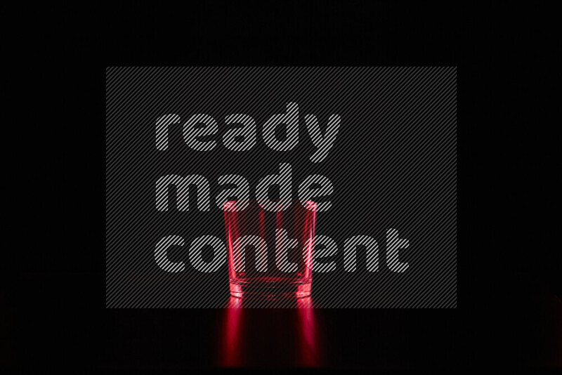 Glassware with rim light in red against black background