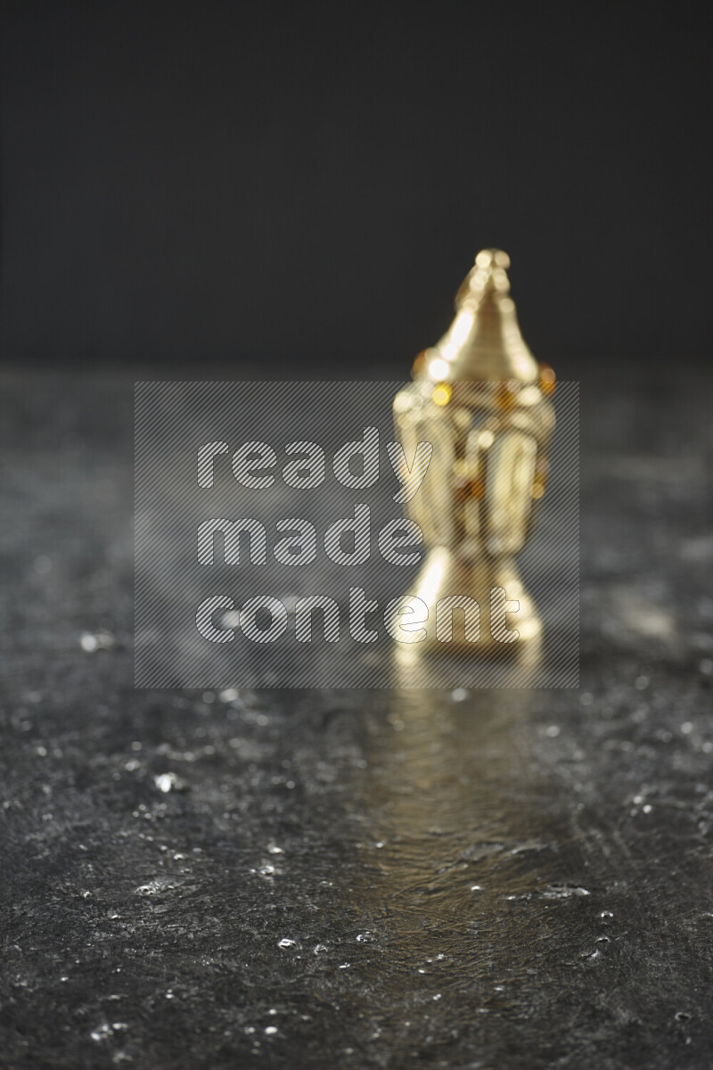 A lantern placed on a textured black background