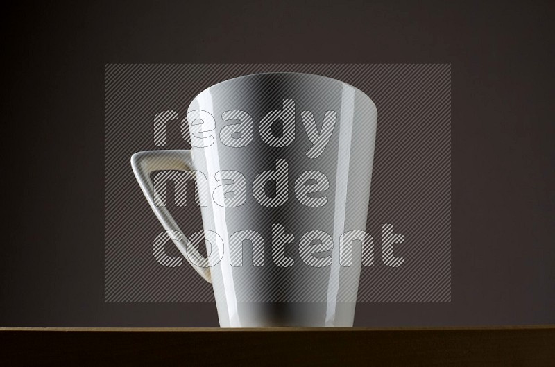 Low angle shot of a white cup on grey background