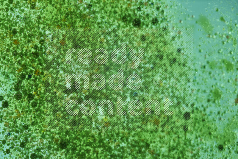 Close-ups of abstract green watercolor drops on oil Surface on green background