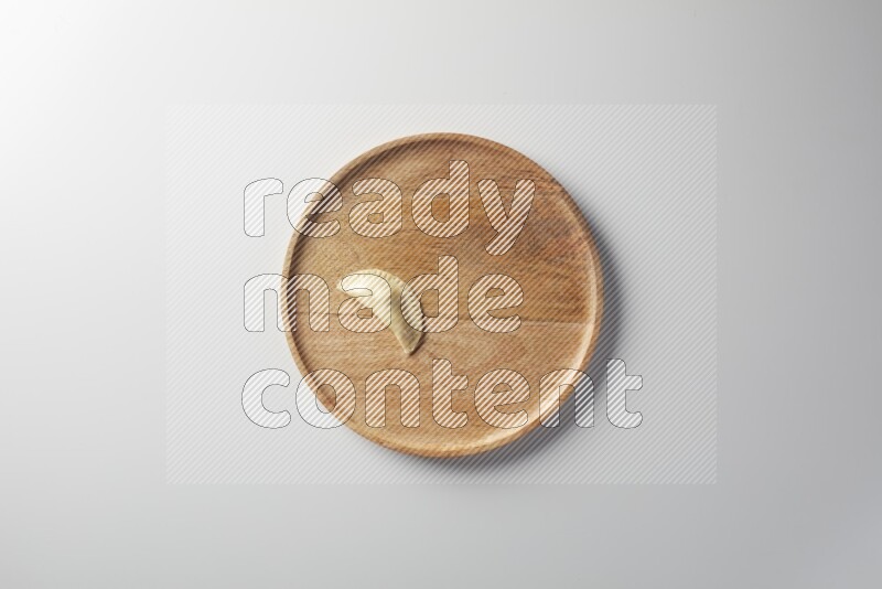 A single Sambosa on a wooden round plate on a white background