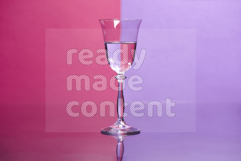 The image features a clear glassware filled with water, set against pink and light purple background