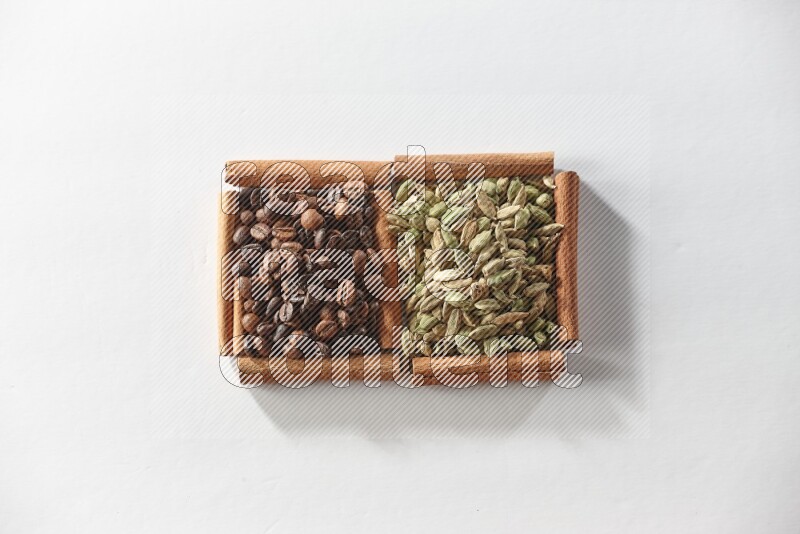 2 squares of cinnamon sticks full of cardamom and coffee beans on white flooring