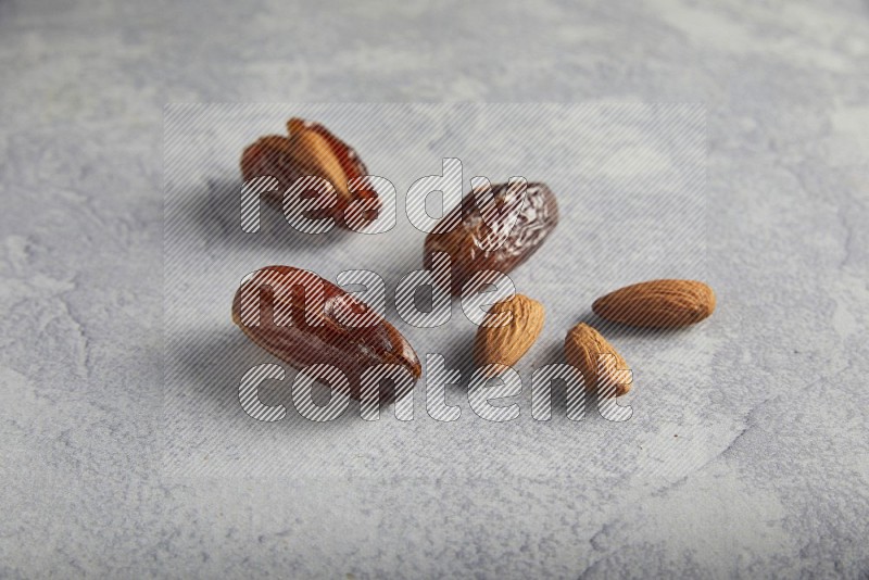 Group of Almonds stuffed dates plain and covered with chocolate on a light grey background