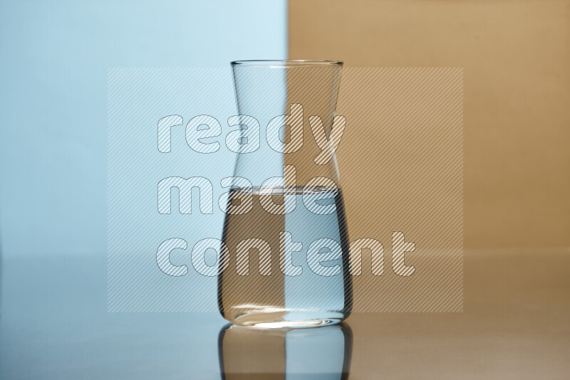 The image features a clear glassware filled with water, set against light blue and beige background