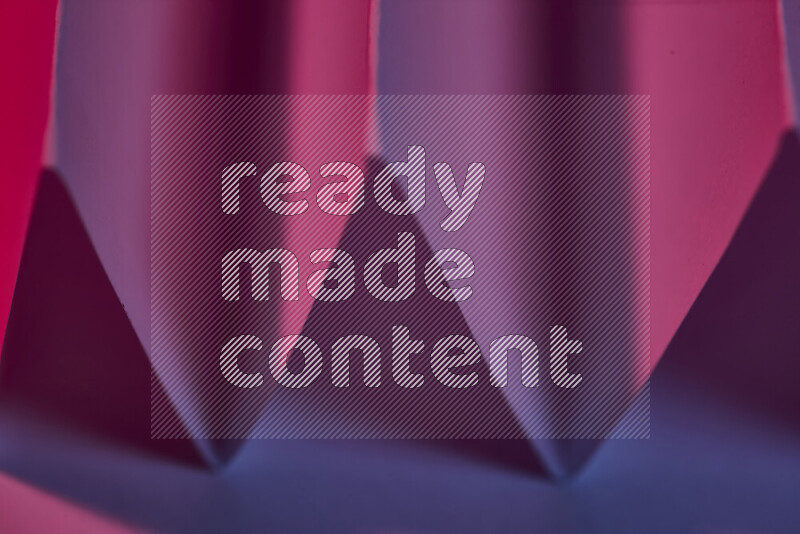 A close-up abstract image showing sharp geometric paper folds in purple gradients