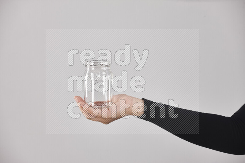 امرأة ترتدي عباءة سوداء تحمل أدوات زجاجية مختلفة في أوضاع متعددة