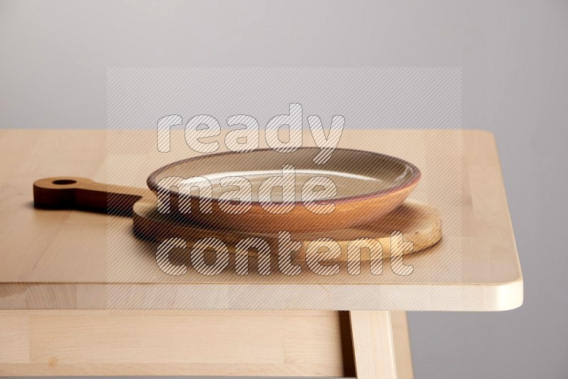 multi colored plate placed on a  wooden oval cutting board on the edge of wooden table