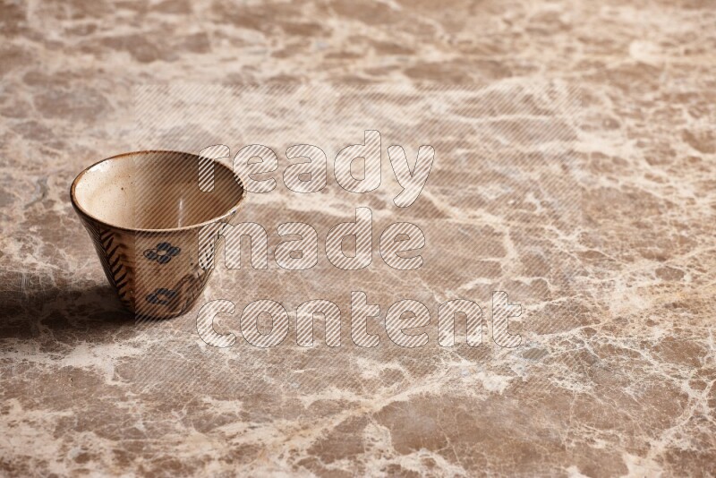 A decorative pottery bowl on beige marble background