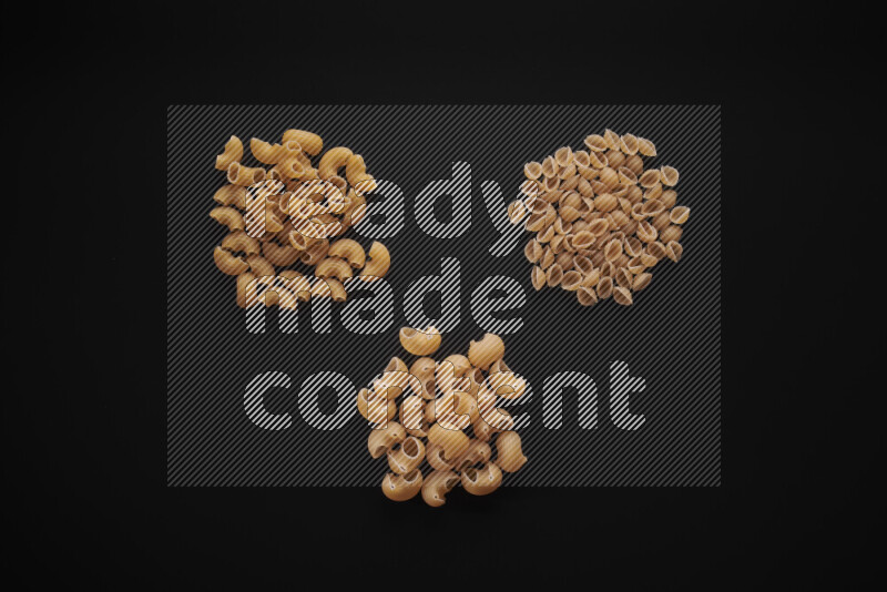 Different pasta types in bunches on black background