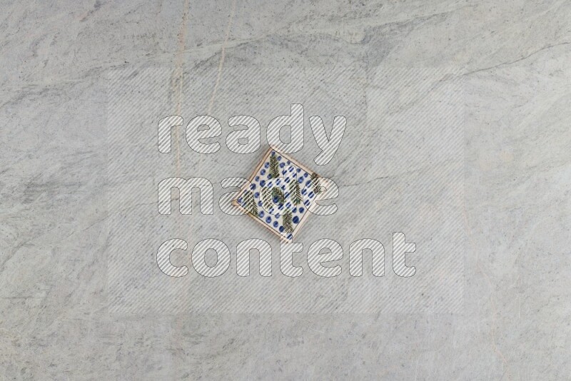 A decorative pottery coaster on grey marble background