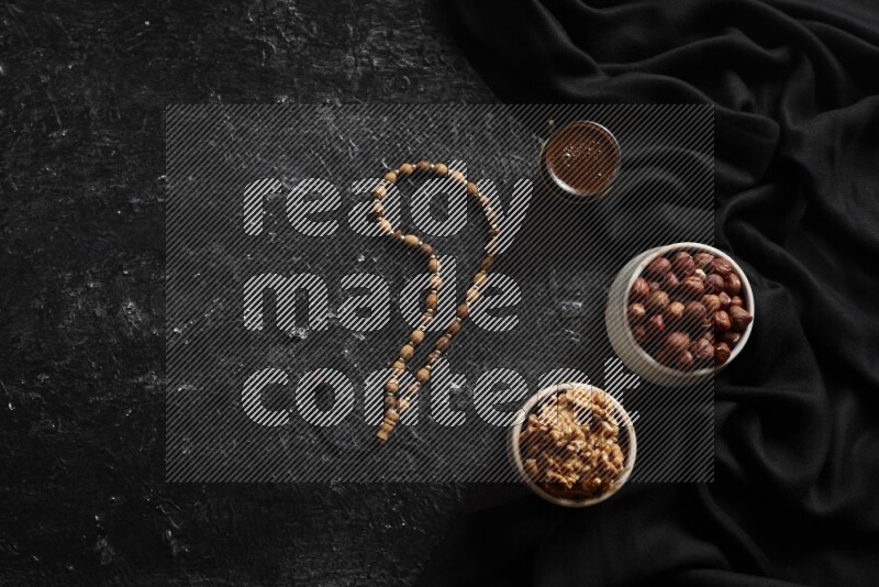 مكسرات في أطباق فخارية مع القهوة علي خلفية سوداء خشبية