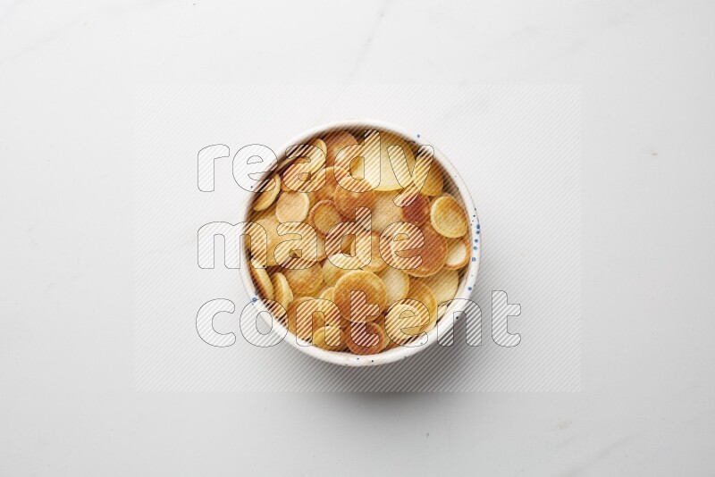 Top-view shot of plain cereal pancakes in a round bowl on white background