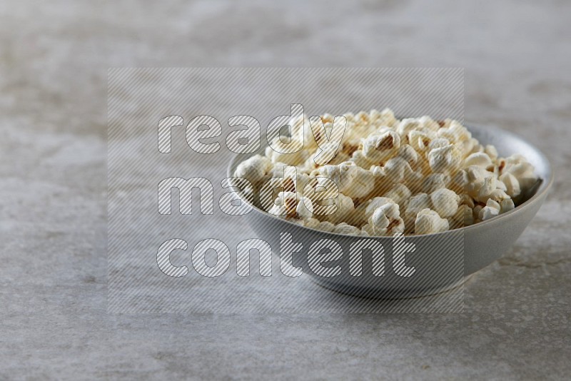 popcorn in gray bowl on a grey textured countertop