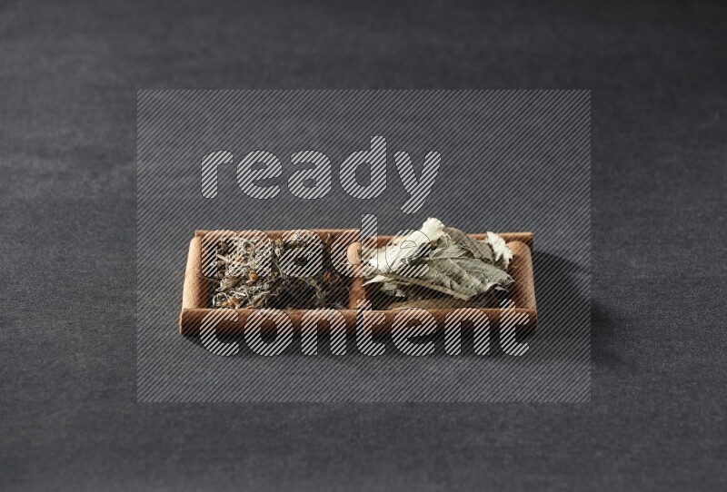 2 squares of cinnamon sticks full of bay laurel leaves and dried basil on black flooring