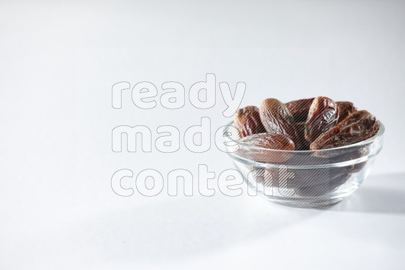 A glass bowl full of dried dates on a white background in different angles