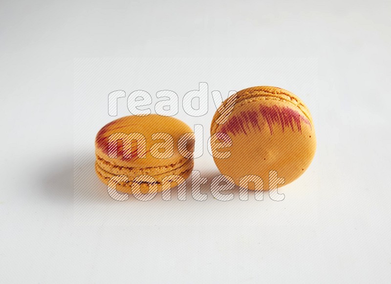 45º Shot of two orange Exotic macarons on white background