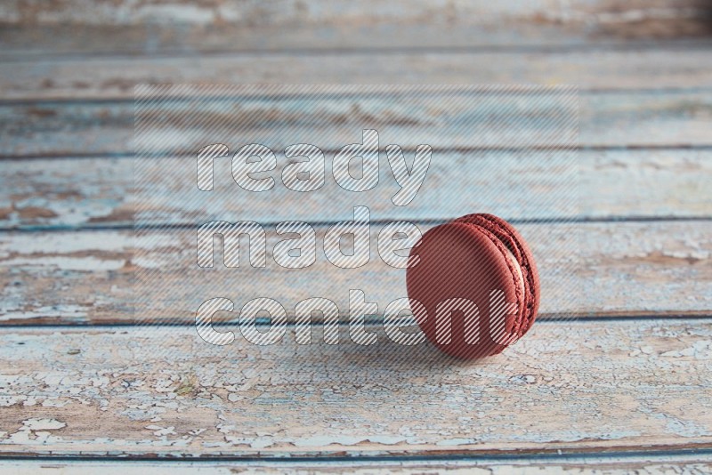 45º Shot of Red Velvet macaron on light blue wooden background