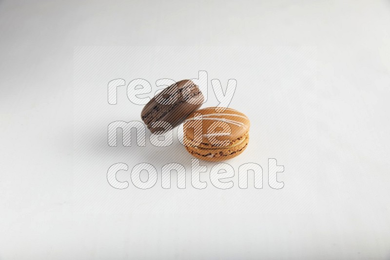 45º Shot of of two assorted Brown Irish Cream, and Brown Dark Chocolate macarons on white background