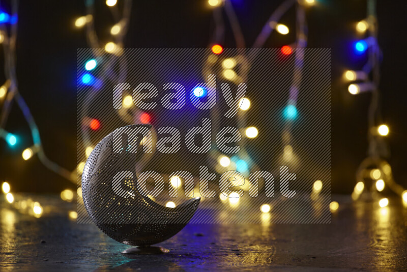 A traditional ramadan lantern surrounded by glowing fairy lights in a dark setup