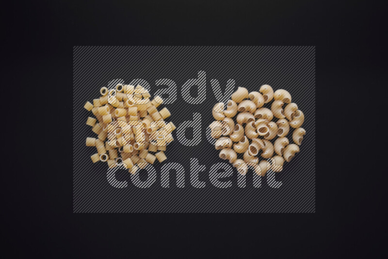 Different pasta types in bunches on black background