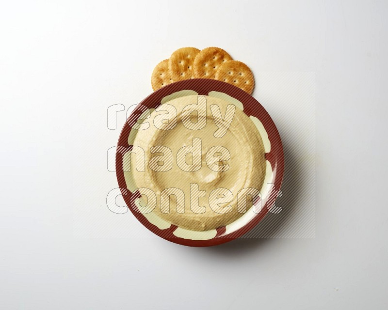 Plain hummus in a traditional plate on a white background