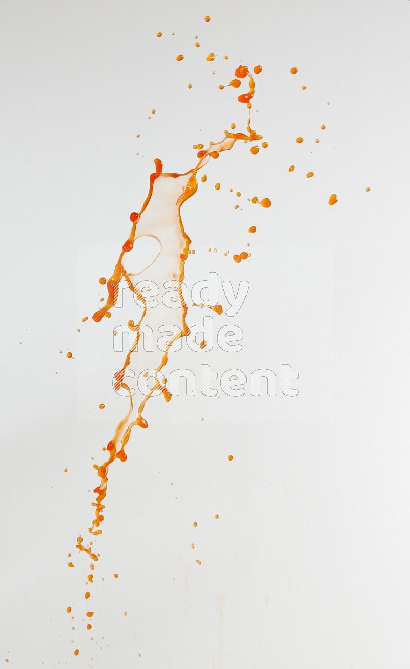 Orange liquid splash and drops on white background