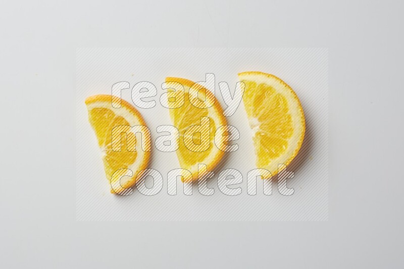 Three halves of an orange slices on white background