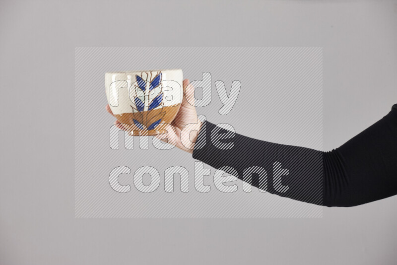 A woman in black abaya holding different pottery essentials in different positions