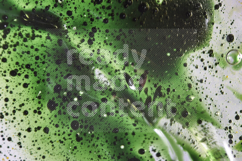 Close-ups of abstract green watercolor drops on oil Surface on white background