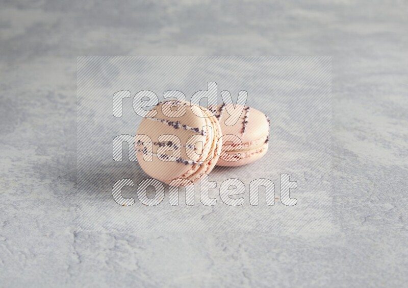 45º Shot of two pink orange blossom macarons  on white  marble background