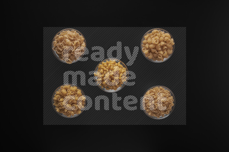 أنواع مختلفة من المعكرونة في أوعية زجاجية علي خلفية سوداء