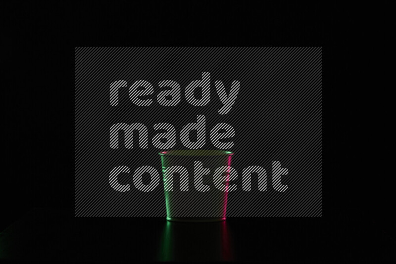 A plant pot with colored rim light against black background