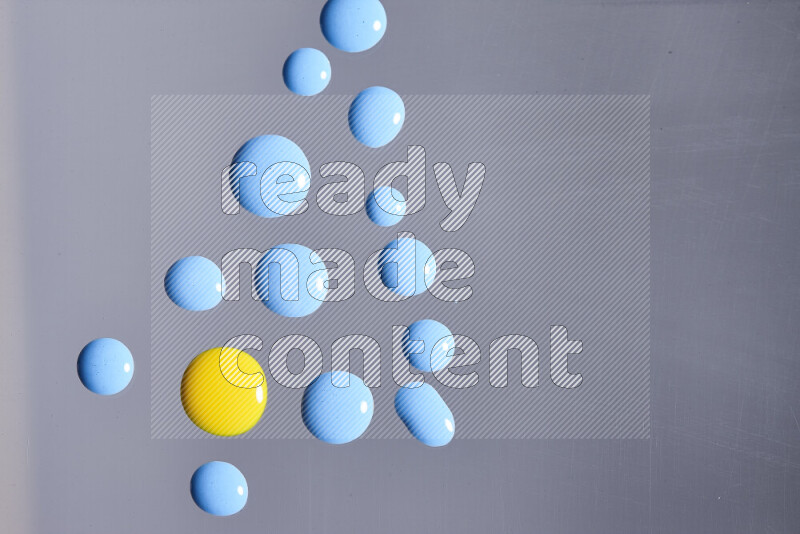 Close-ups of abstract blue and yellow paint droplets on the surface